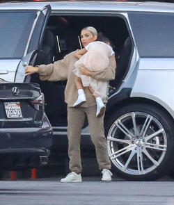 Kim Kardashian carrying a sleepy princess Nori