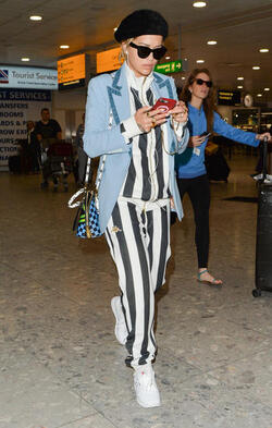 Rita Ora in a Striped Track Suit at Heathrow Airport