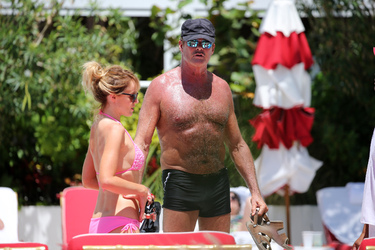 Baywatch actor David Hasselhoff wears tiny black swim trunks as he relaxes with his bikini clad finance Hayley Roberts by the pool in Miami.