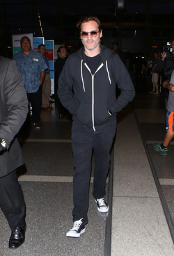 The enigmatic Joaquin Phoenix sports a scruffy beard zip up hoodie and shades as he spends National Brother s Day catching a flight with his lovely sister Summer.