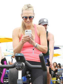 Molly Sims rides a stationary bike for charity