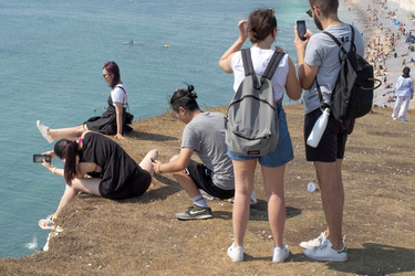 Tourist Leans Over Cliff Edge To Take Picture Of Friend
