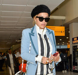 Rita Ora in a Striped Track Suit at Heathrow Airport
