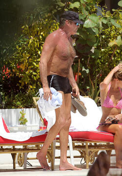Baywatch actor David Hasselhoff wears tiny black swim trunks as he relaxes with his bikini clad finance Hayley Roberts by the pool in Miami.