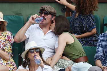 Jean Dujardin and his wife Nathalie Pechalat keep each other moisturised at the French Tennis Open at Roland Garros
